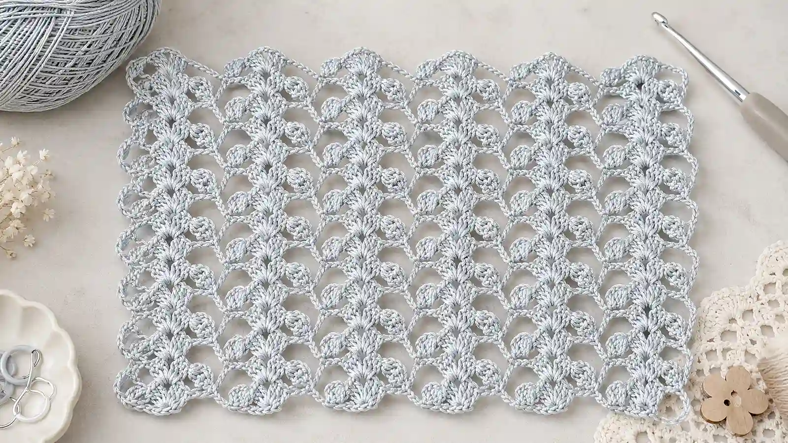 Muestra de puntada calada a crochet en color gris claro.