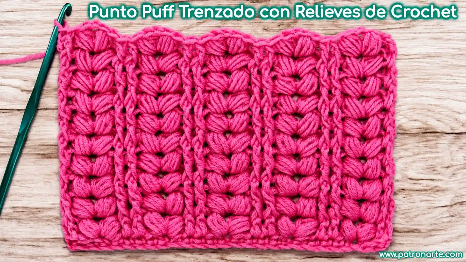Muestra de punto puff trenzado a crochet en color fucsia, con columnas en relieve sobre una mesa de madera.